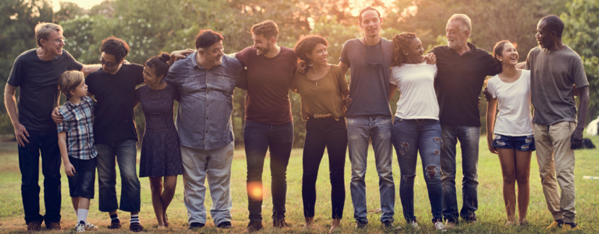 Diverse group of volunteers linking arms, smiling and talking to each other.